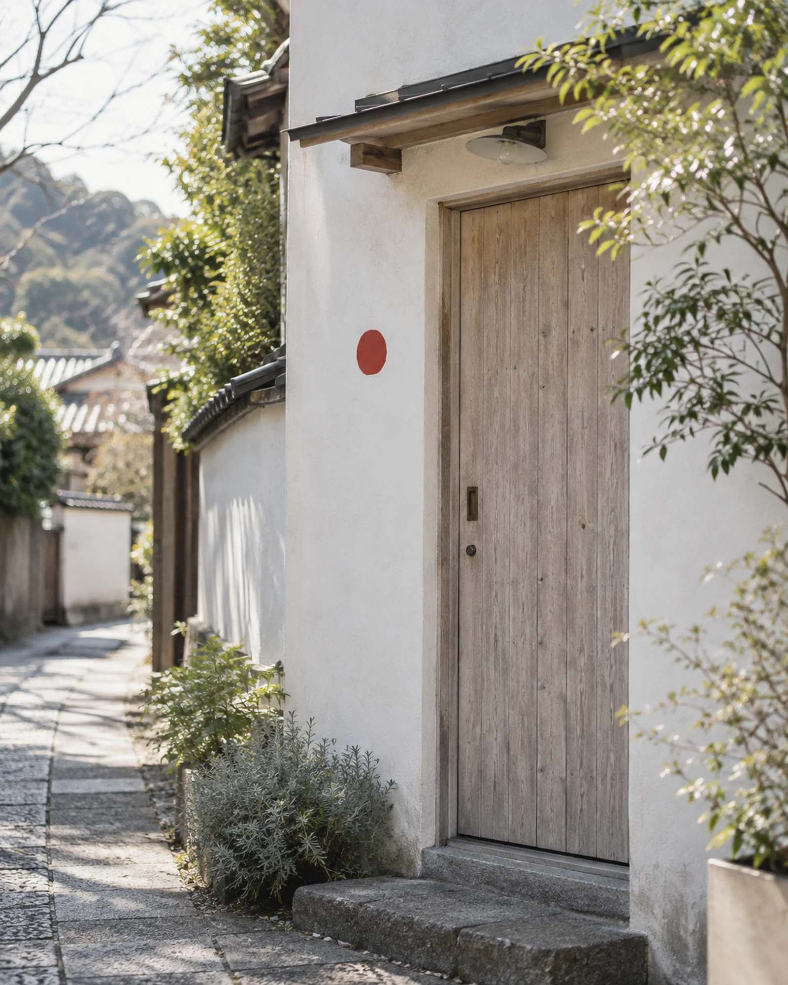 白い壁の路地にある小さな木の扉と、赤い印